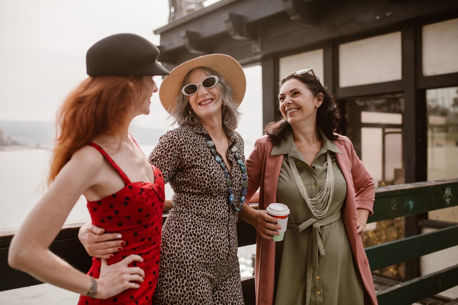 Três amigas de meia-idade rindo juntas ao ar livre. Capa do Guia da Menopausa